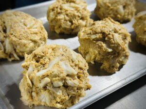 Crab cakes on a metal baking tray.