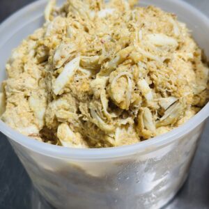 Container of shredded chicken with spices.
